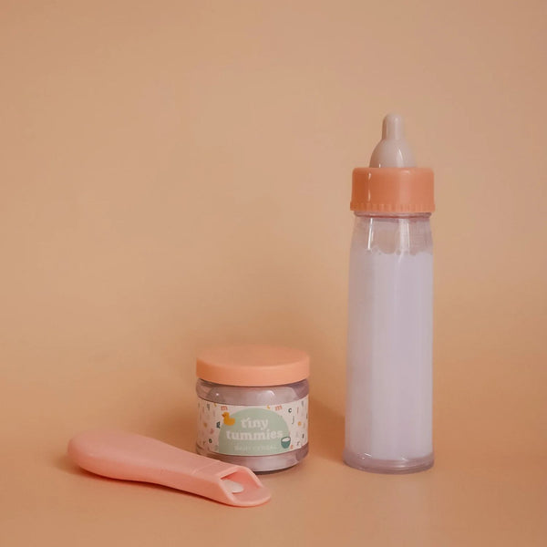Coffret Tiny Harlow pour nourrir les poupées comme un vrai parent. Biberon magique et petit pot de céréales pour un jeu d’imitation réaliste et créatif dès 3 ans.