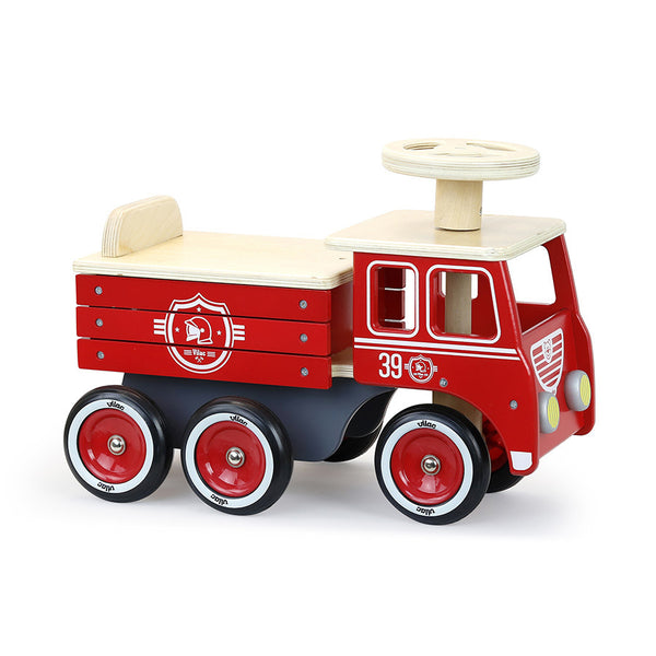 Porteur camion de pompier en bois dès 18 mois. Stable, 6 roues silencieuses et coffre de rangement intégré.