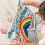 Bébé manipulant journal en tissu météo, exploration tactile sécurisée