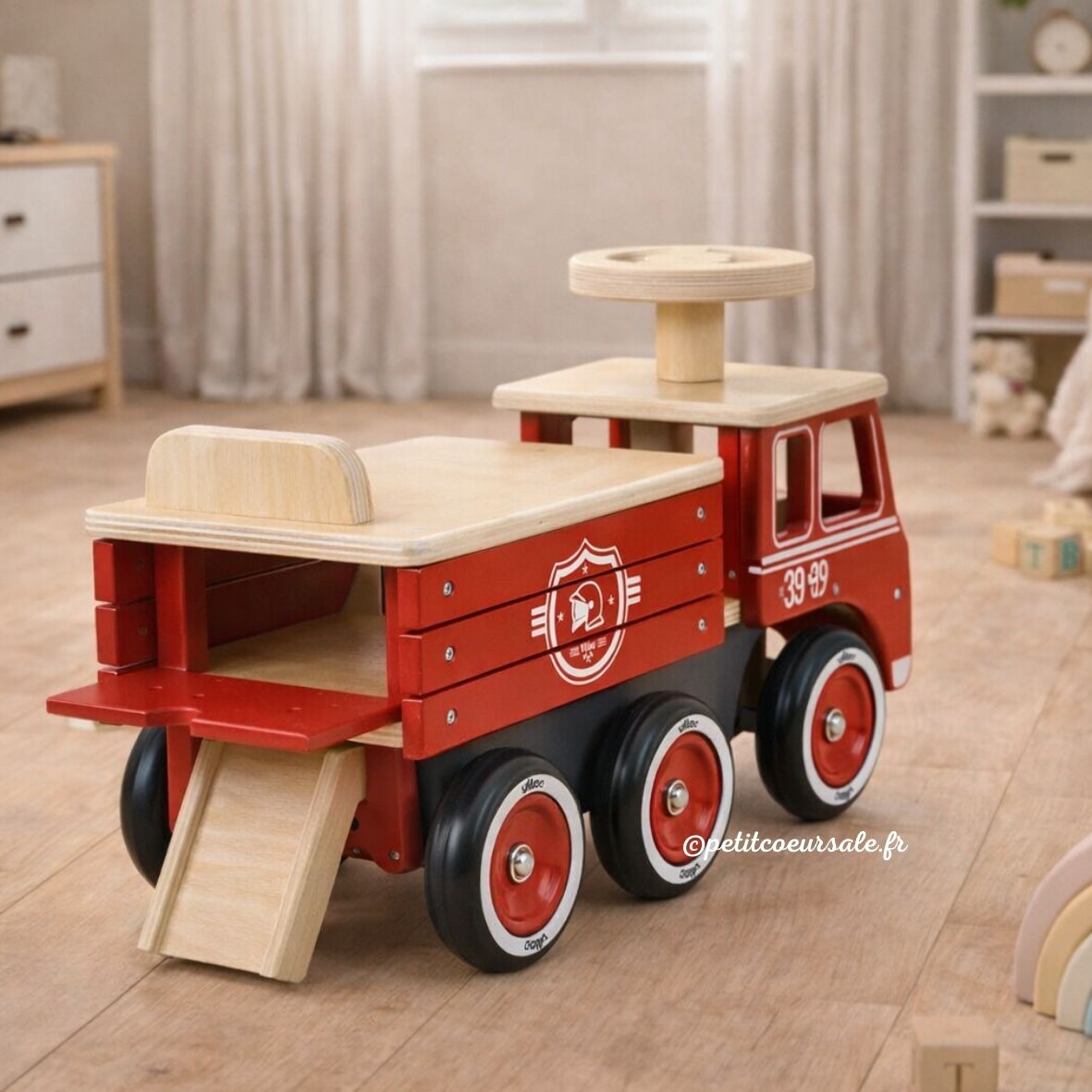 Porteur camion de pompier en bois dès 18 mois. Stable, 6 roues silencieuses et coffre de rangement intégré.