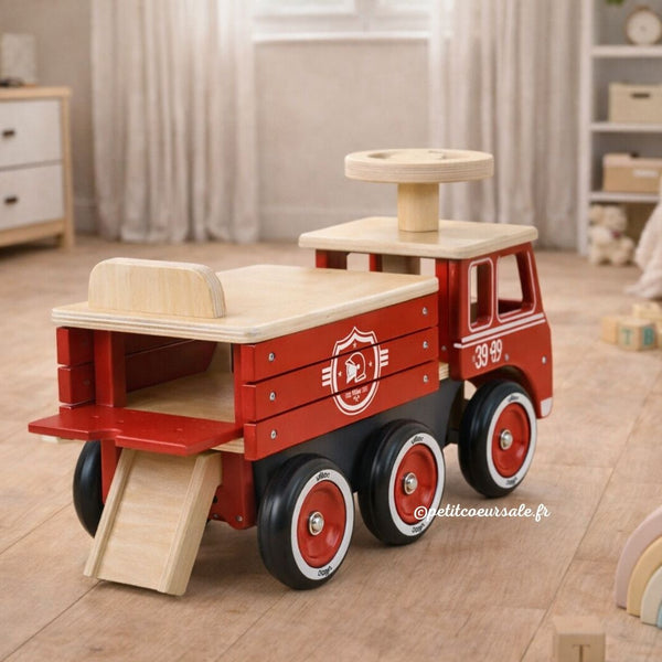 Porteur camion de pompier en bois dès 18 mois. Stable, 6 roues silencieuses et coffre de rangement intégré.