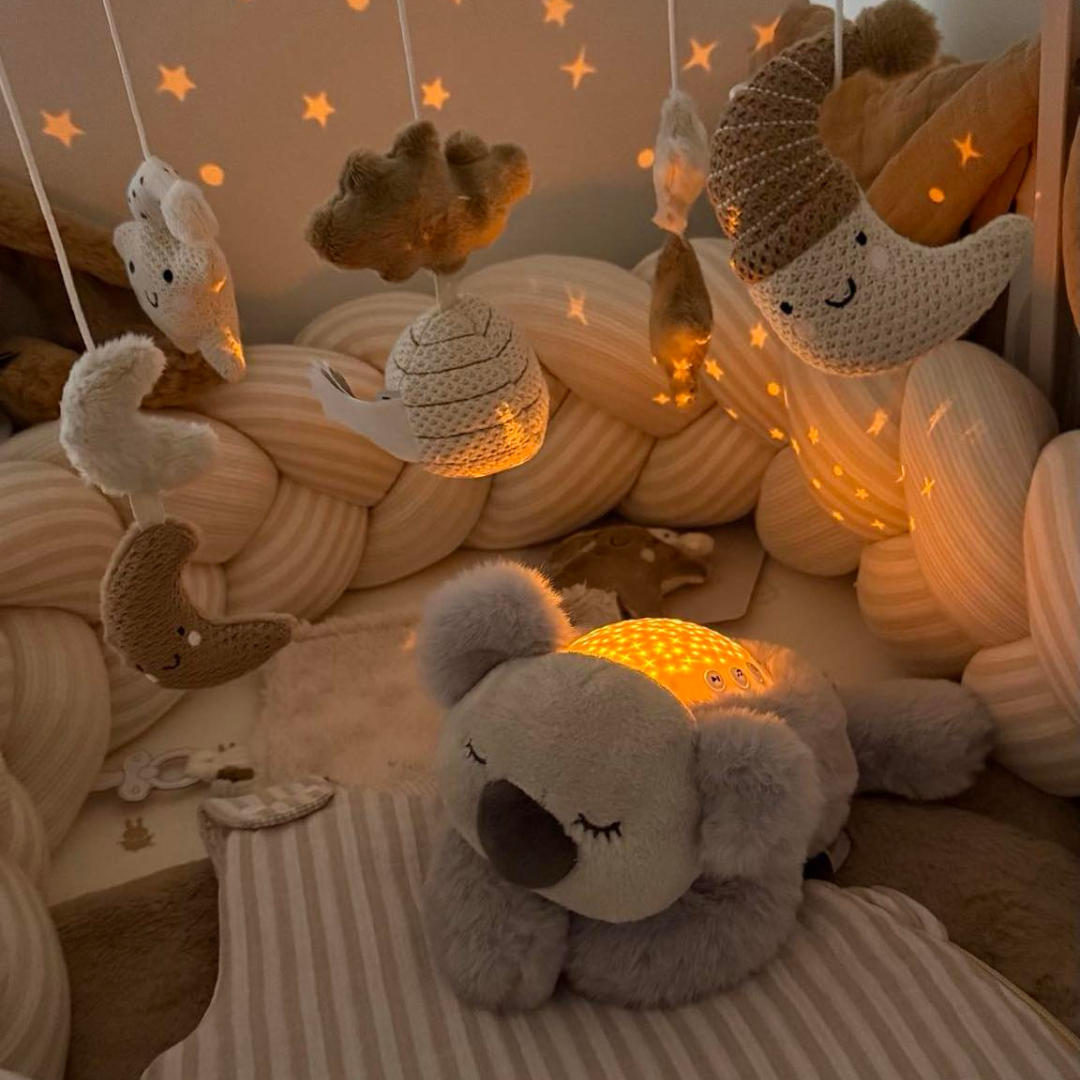 Veilleuse peluche pour bébé avec projection d’étoiles et sons relaxants. Timer 20 min, lumière douce et câline pour un sommeil paisible.