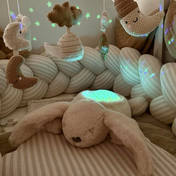 Veilleuse peluche bébé avec projection d’étoiles et sons apaisants. Lumière douce, timer 20 min, parfait pour endormir bébé en toute sécurité.
